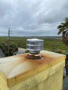 A sturdy chimney cap installed on a rooftop in Pensacola Beach, Florida.